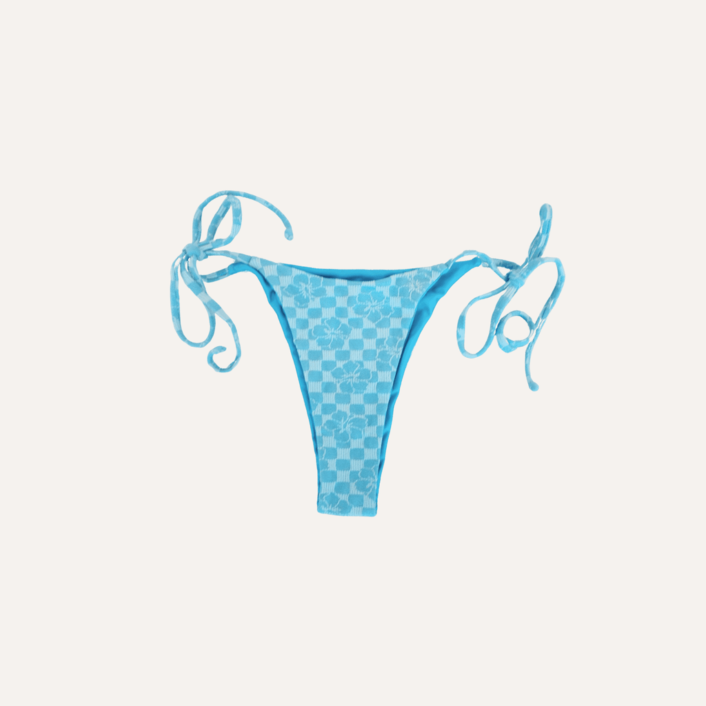 Light blue checkered bikini bottom with floral accents and adjustable side tie strings, designed for a stylish and comfortable summer beachwear look. | PicSEO 1778549003376