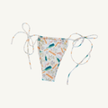 Close-up image of a women's bikini bottom featuring adjustable side ties and a colorful print with bottles, bread, leaves, and text in pastel tones on a white background, highlighting its stylish and playful beachwear design. | PicSEO 1778548920291