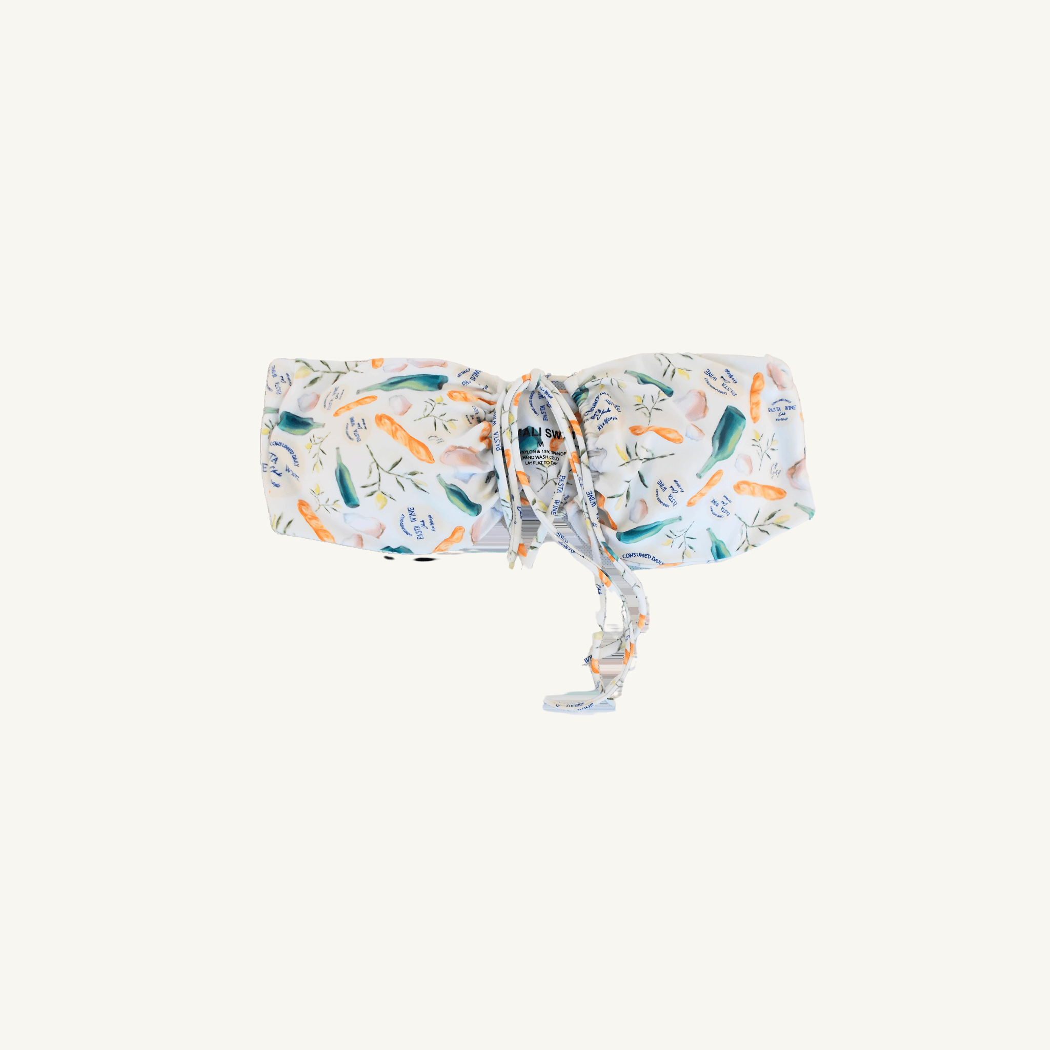 A stylish white bandeau bikini top featuring a colorful print of various vegetables and herbs, accented with text elements, and designed with a front tie detail for adjustable fit and trendy beachwear appeal. | PicSEO 1778548962890