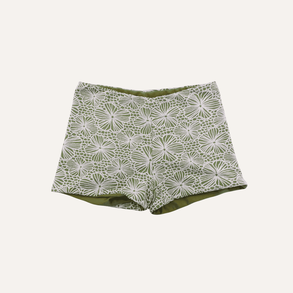 Olive green shorts featuring a white floral and geometric lace pattern, designed with a fitted waistband and a clean, tailored silhouette for a stylish and elegant look. | PicSEO 1778308081015