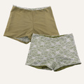Pair of women's shorts featuring an olive green base with contrasting white floral lace overlay at the waistband and hem, combining a simple solid color with intricate delicate patterns for a stylish and feminine look. | PicSEO 1776735105892